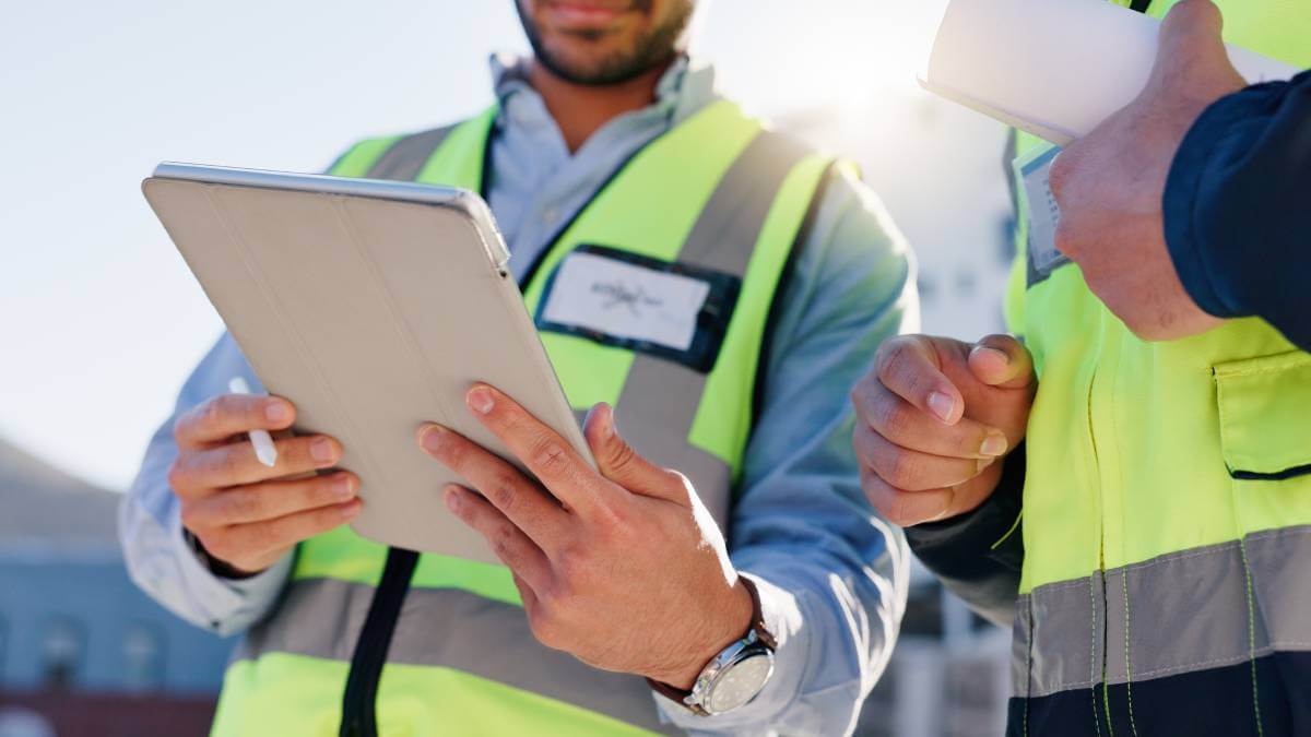 A picture of two workers looking at a screen